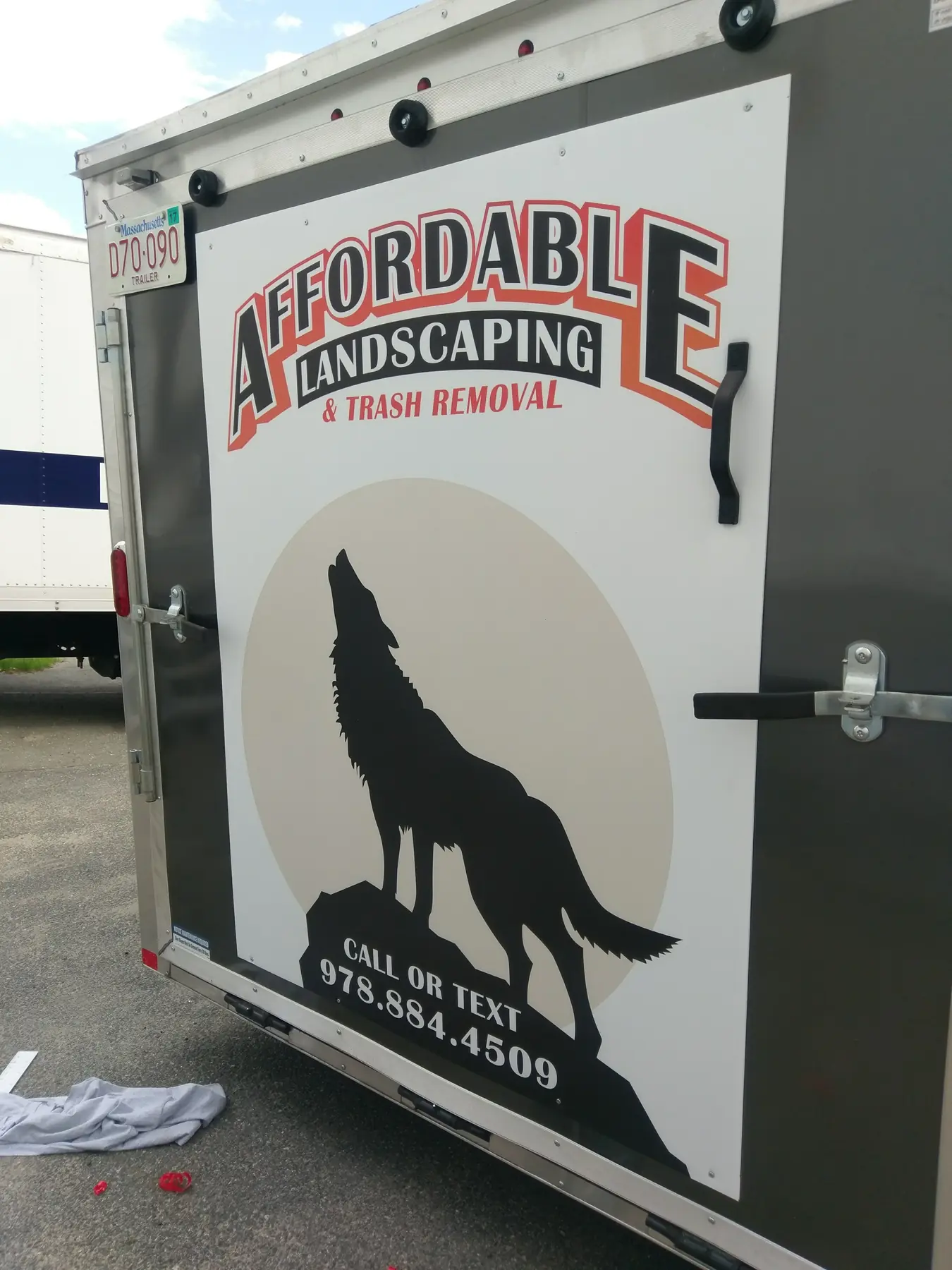 Affordable Landscaping trailer rear with illustrated wolf graphics and business information